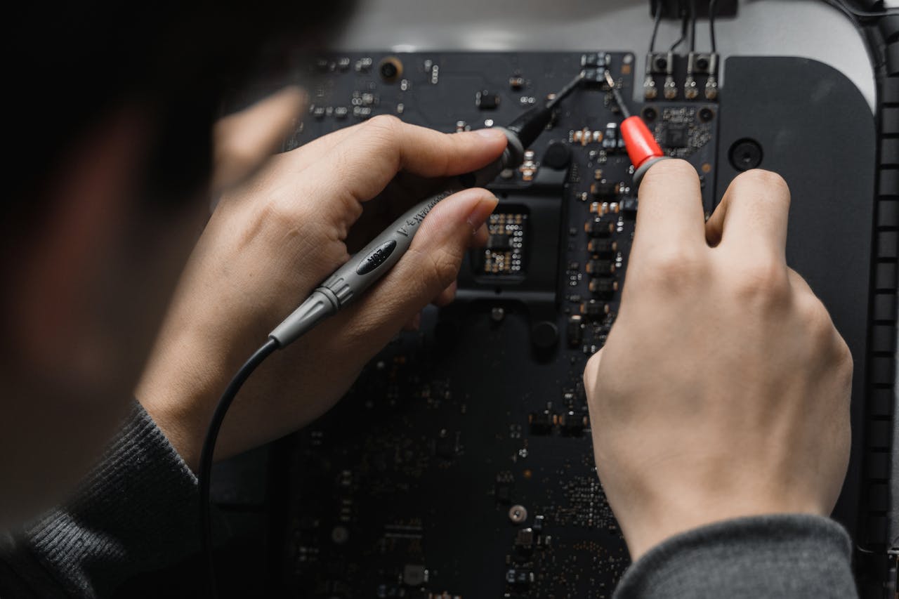 Home Close-up of hands repairing a circuit board using a soldering iron, emphasizing technical skill.